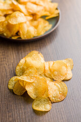 Crispy Potato Chips on wooden table.