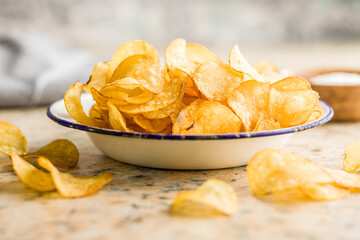 Crispy Potato Chips in bowl on kitchen table.