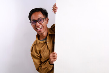 Portrait of young glad excited cheerful positive Indonesian civil servant man demonstrating copy...