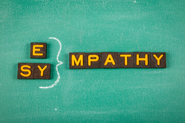 Empathy and Sympathy Concept. Old letter tiles on a green chalkboard background