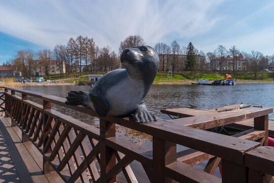 Sortavala, Russia - May 15, 2024: Wooden sculpture of a seal against the backdrop of the Vakkolahti Bay at the Sortavala-Center railway station.