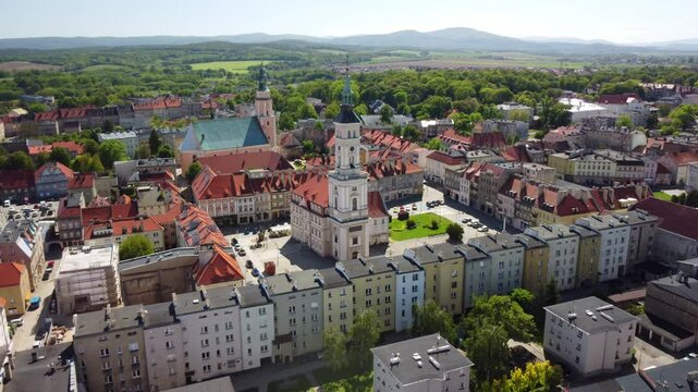 Aerial footage of Prudnik, capturing the historic town center with its distinctive church, town hall, and charming red-tiled roofs