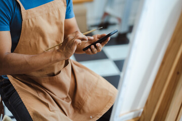 Obraz premium Creative painter painting in an art studio. Artistic young man working on a new painting.