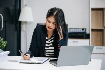 Woman who is tired and overthinking from working with tablet and laptop at modern office..