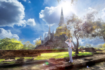 Naklejka premium Young woman traveling in temple, Asian traveler take a photo temple in Ayutthaya Historical Park UNESCO World Heritage Site.Asian female tourist taking pictures at Wat Phra Si Sanphet in Ayutthaya