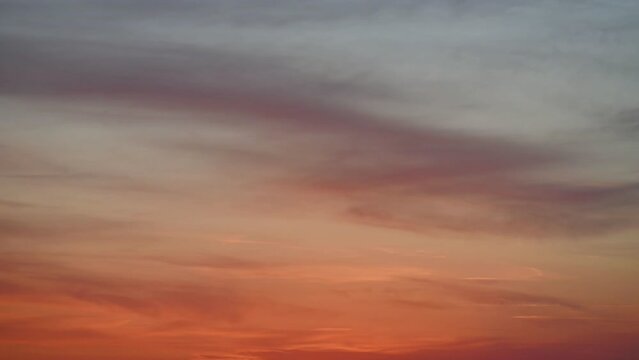 Niebo o zachodzie słońca, leniwie przesuwające się obłokiem ma pomarańczowym niebie