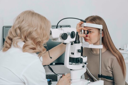 Ophthalmologist examining patient's eyes with slit lamp at medical clinic