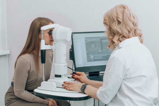 Mature doctor examining woman eyes with slit lamp at clinic