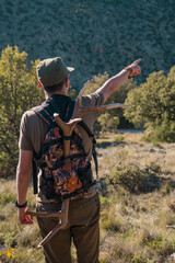 Person carrying a deer antler in his backpack pointing at something.