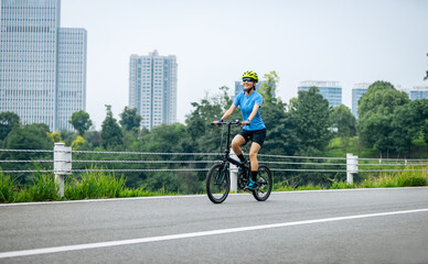 Riding a fold bike with modern city in the distrance