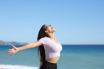 Happy woman screaming on the beach