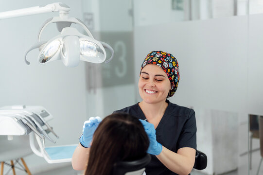Happy dentist examining patient in clinic
