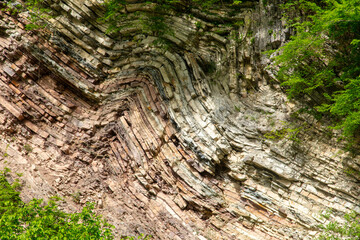 Mountain rocks in green vegetation as a background. Texture