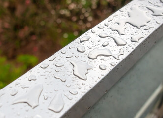 Drops of water from rain on a metal railing
