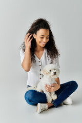 Woman peacefully sits with her white Bichon Frise on the floor.