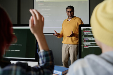 Selective focus shot of mature biracial teacher conducting Computer Science lesson, unrecognizable...