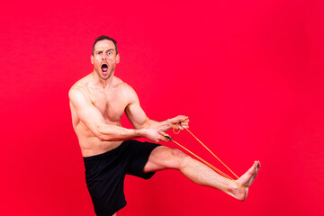 Full length portrait of a young man exercising with a skipping rope and looking at the camera