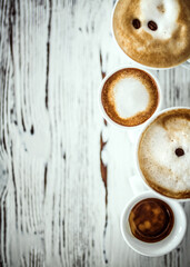 Cups with hot espresso, cappuccino, latte on table. Shot with copy space.
