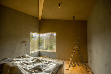 Bedroom with corner window during repairing of a house on nature. Creative process of home renovation and repair concept