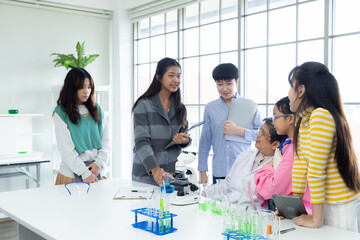 Asian students in science class performing chemial experiments with test tubes and microscopes...