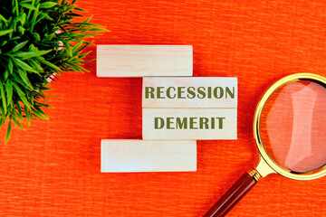 Business and recession fears concept. Copy space. Concept words Recession fears on wooden blocks with a flower and a magnifying glass in the composition . Beautiful orange background