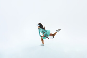 Obraz premium Overhead view shot of young athletic woman prepares to hitting ball with racquet against white studio background. Concept of professional sport, championship, active lifestyle, tournament. Ad