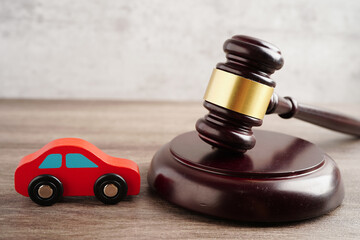 Car accident lawsuit and insurance, Judge hammer with car model.