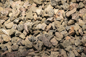 A close up image of a pile of crushed stone with varying shades of gray and brown. The stone is likely used for landscaping or construction purposes