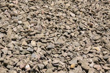 A close-up view of a gravel surface composed of small, gray, crushed stones