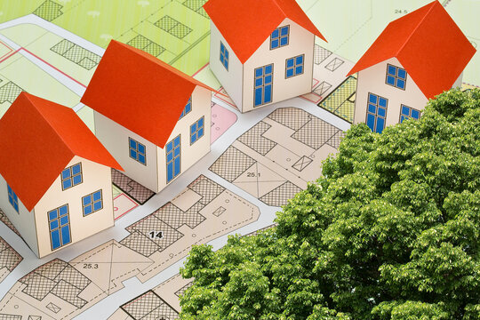 Imaginary cadastral map of territory with buildings and land parcel - Planning a new home and living in nature concept with home model and tree