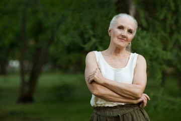  lifestyle portrait senior woman  with gray hair relaxes in summer outdoor. spends time in nature.  copy space. greyhairdontcare. 