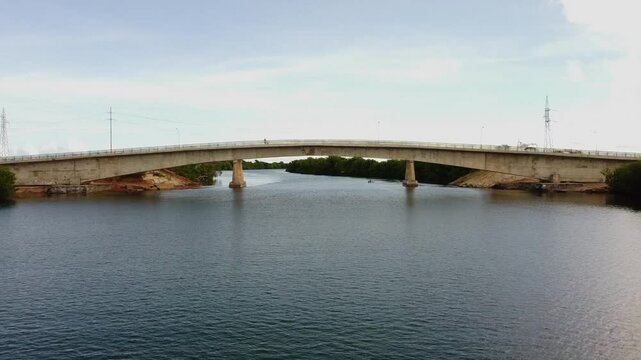 Drone Shot, Flying Over River At Low Altitude Then Passing Under Concrete Bridge