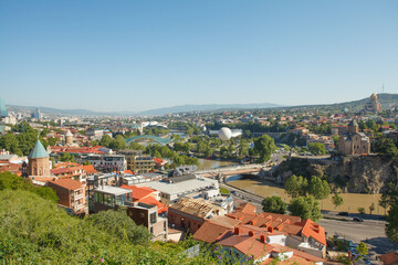 Fototapeta premium Landscape of old town Tbilisi and river on the background of blue sky and green mountains