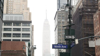 New York City crossroad, street intersection road sign on post. Empire State building, Midtown district, West 34, NYC, United States. Highrise skyscraper architecture, 9th avenue corner text roadsign.