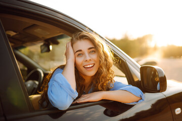 Happy young woman looking out of window while traveling by car.  Lifestyle, travel, tourism, nature, active life