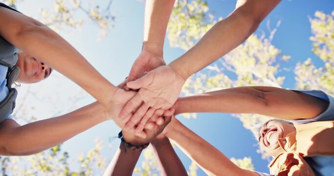 People, huddle and hands in air outdoor for success of community service or program, collaboration and teamwork. Diversity, unity and applause to celebrate for development, social justice and ngo.