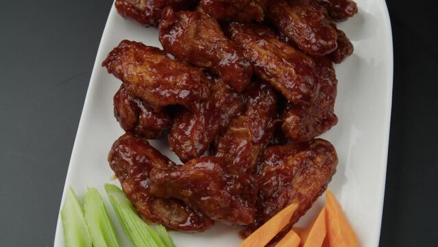 Fried wings and vegetables in a plate. Close-up. Selective focus.