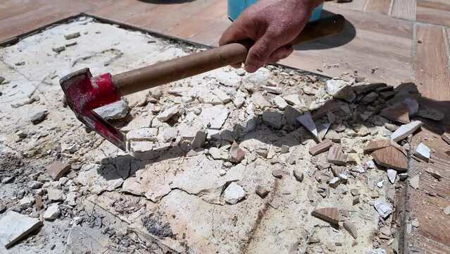 Construction worker hitting the ground with a hammer