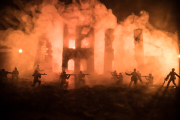 Fototapeta premium War Concept. Military silhouettes fighting scene on war fog sky background, World War Soldiers Silhouette Below Cloudy Skyline At night. Battle in ruined city.