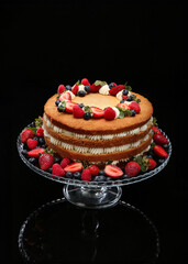 Fruit sponge cake decorated with strawberries and blueberries