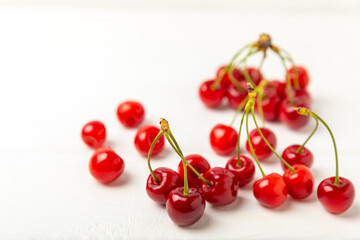Cherries. Fresh ripe cherries with leaves on a textured wooden background. Fresh sweet organic cherry pile. Berries and fruits. Vegan. Healthy eating. Place for text. Copy space