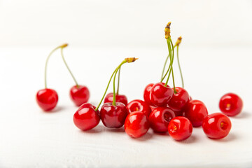 Cherries. Fresh ripe cherries with leaves on a textured wooden background. Fresh sweet organic cherry pile. Berries and fruits. Vegan. Healthy eating. Place for text. Copy space