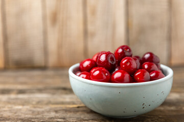 Cherries. Fresh ripe cherries with leaves on a textured wooden background. Fresh sweet organic cherry pile. Berries and fruits. Vegan. Healthy eating. Place for text. Copy space
