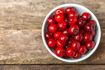 Cherries. Fresh ripe cherries with leaves on a textured wooden background. Fresh sweet organic cherry pile. Berries and fruits. Vegan. Healthy eating. Place for text. Copy space