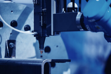 Robot arm with laser CNC cut of metal with light spark. Modern technology industrial, blue color