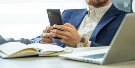 Close up, business man using mobile smart phone on wooden table. man using smartphone during working at office with digital tablet on table, social network, business success 