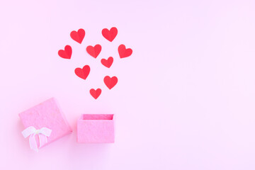 Pink gift box with red paper hearts on pink background, Handmade paper box and papercut