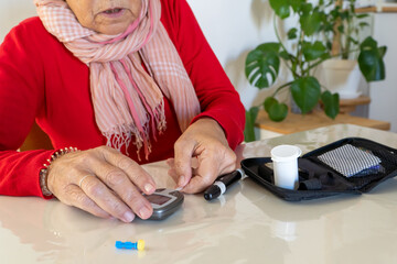 Patient with diabetes handling a domestic kit to check sugar on blood levels at home