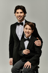 A father and son in formal attire, smiling and sharing a moment together.