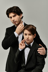 A father and son, both dressed in formal attire, stand side by side, showcasing a bond of love and pride.